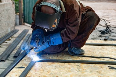 Elektrik kaynakçısı bir boruyu kaynaklama ve elektrot ile birleştirerek metal bir yapı oluşturur..