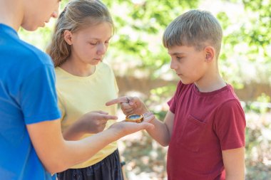 Elinde pusula olan çocuklar hangi yöne gideceklerini tartışıyorlar..