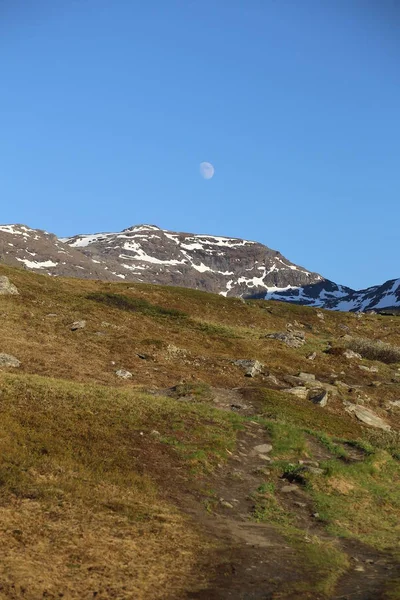 Měsíc nad horami a travnatými porosty v údolí Karkevagge v severním Švédsku — Stock fotografie