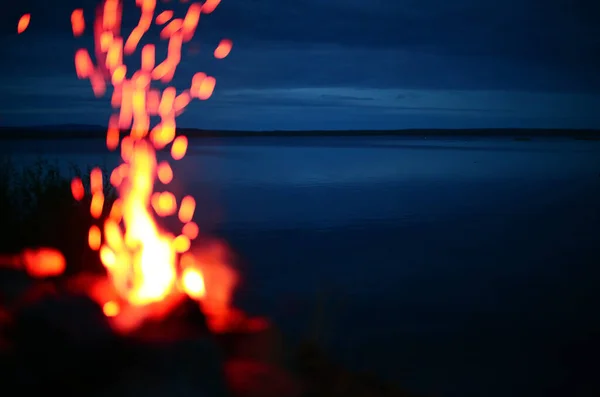 Falò sfocato di fronte al lago Malgomaj in Svezia — Foto Stock