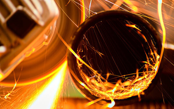 Резка металлической трубы с помощью углового шлифовального станка.