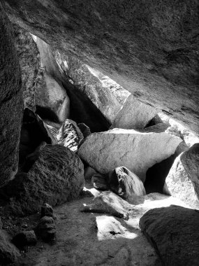 Büyük kayalar ve doğal ışık ile kaya mağarası engebeli taş oluşumunda kontrastlık yaratır..