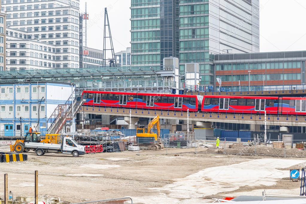 Construction site in Canary Wharf in London with DLR trains arriving station