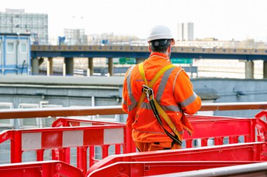 Arkadan görünüşü bir şantiye Canary Wharf, Londra, içine yürüyüş bir inşaat işçisi