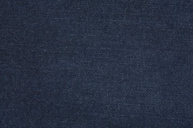 Denim kot desenli yırtık. Renkli pamuk kumaşın dokusu. Dikilmiş desenli kot pantolon. Moda pantolonu düğmesi. Kotun üzerindeki perçin ve cep. İplik ve kumaş yapısı.