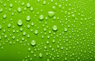 Küçük ve büyük renkli bir arka plan üzerinde su damlacıkları. Soyut sıvı spreyler