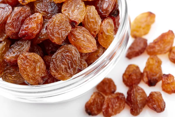 bowl of raisins on a white background. Dried grapes.