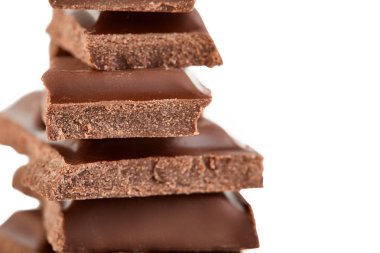 Beyaz arkaplanda izole edilmiş sütlü çikolata parçaları.