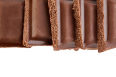 Beyaz arkaplanda izole edilmiş sütlü çikolata parçaları.