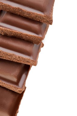 Beyaz arkaplanda izole edilmiş sütlü çikolata parçaları.