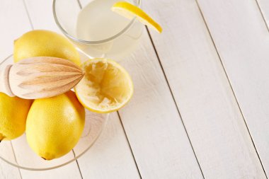 Taze sıkılmış limon suyu. Bir bardak sıkılmış limon suyu ve limon çevresinde. Vitaminler. Narenciye meyve. Sarı.