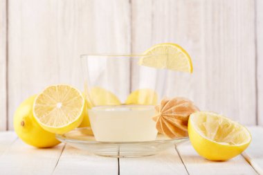 Taze sıkılmış limon suyu. Bir bardak sıkılmış limon suyu ve limon çevresinde. Vitaminler. Narenciye meyve. Sarı.