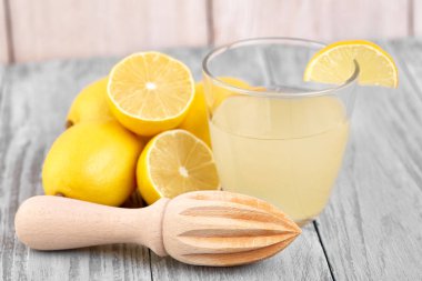 Taze sıkılmış limon suyu. Bir bardak sıkılmış limon suyu ve limon çevresinde. Vitaminler. Narenciye meyve. Sarı.