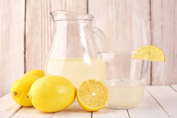 Freshly squeezed lemon juice. A glass of squeezed lemon juice and lemons around. Vitamins. Citrus fruits. Yellow.