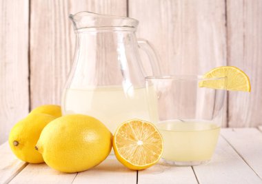 Taze sıkılmış limon suyu. Bir bardak sıkılmış limon suyu ve limon çevresinde. Vitaminler. Narenciye meyve. Sarı.