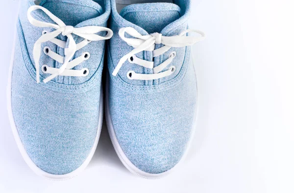 Blue sneaker on a white background. Cyan classic sneakers with white laces on a white rubber sole on white background. Sports, city footwear.