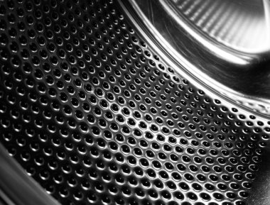 Çamaşır makinesi davul iç. Otomatik çamaşır makinesi için delikli paslanmaz çelik tambur. Siyah ve beyaz, Metalik arka plan