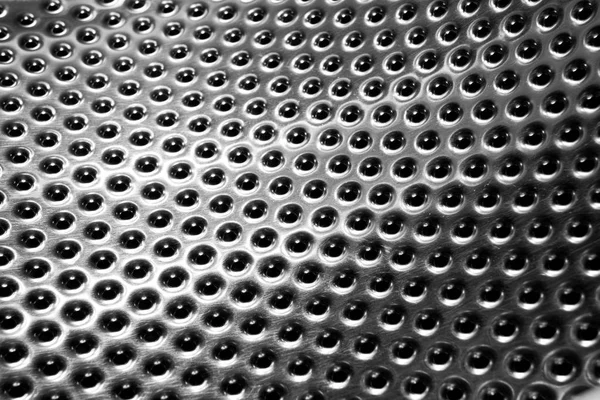 Washing machine drum interior. Perforated stainless steel drum for automatic washing machine. Black and white, metallic background