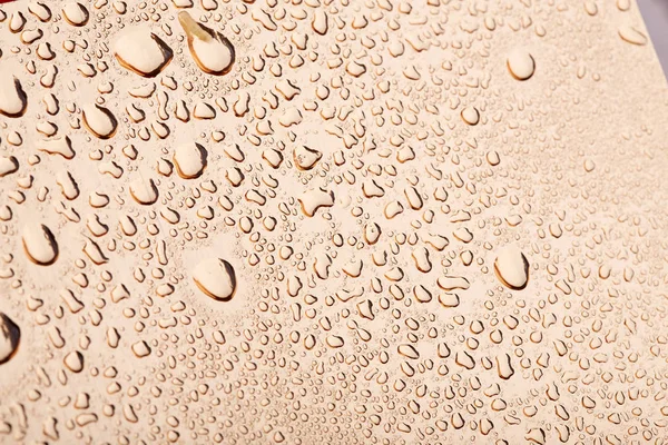 Colored water droplets on a gold background. Abstract liquid sprays