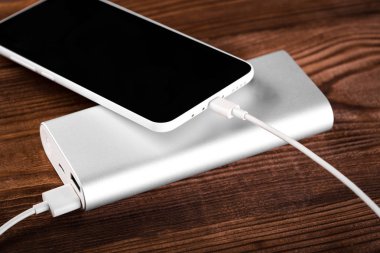 Mobil cihazları şarj etmek için pil banka. Gümüş akıllı telefon şarj cihazı gücü Bankası ile. Mobil cihazlar için harici pil.