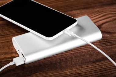 Mobil cihazları şarj etmek için pil banka. Gümüş akıllı telefon şarj cihazı gücü Bankası ile. Mobil cihazlar için harici pil.