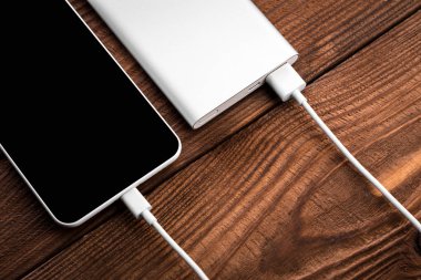 Mobil cihazları şarj etmek için pil banka. Gümüş akıllı telefon şarj cihazı gücü Bankası ile. Mobil cihazlar için harici pil.