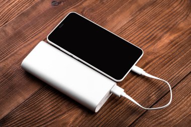 battery bank for charging mobile devices. Silver smart phone charger with power bank. External battery for mobile devices. clipart