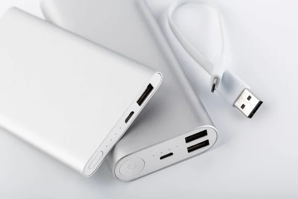 Power bank for charging mobile devices. White smart phone charger with power bank. battery bank. External battery for mobile devices.