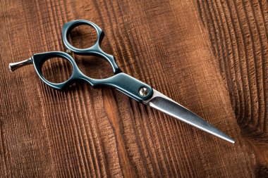 Saç düzeltici ve ahşap arka plan için makaslar. Sakal ve saç kesme makineleri.