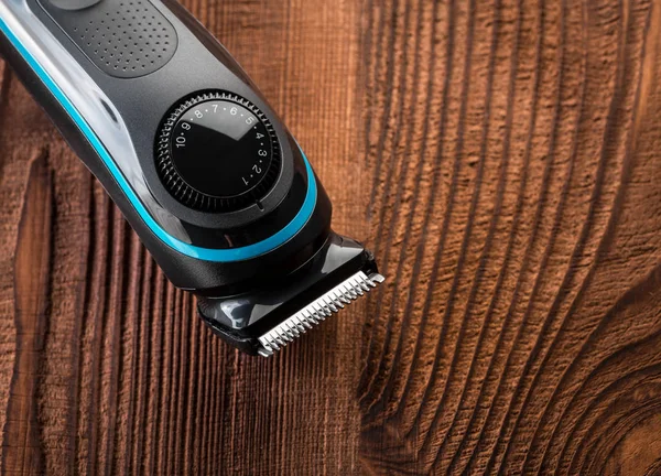 Hair trimmer and scissors on the wooden background. Beard and hair clippers.