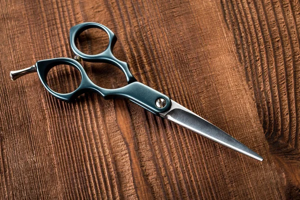 Saç düzeltici ve ahşap arka plan için makaslar. Sakal ve saç kesme makineleri.