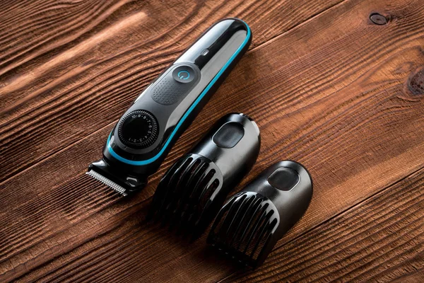 Hair trimmer and scissors on the wooden background. Beard and hair clippers.