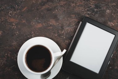 E-kitap ve kağıt kitap bir fincan kahve, bir dizüstü bilgisayar ve okuma gözlükleri tablo. Kendi kendine eğitim kavramlarını.