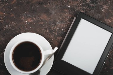 E-kitap ve kağıt kitap bir fincan kahve, bir dizüstü bilgisayar ve okuma gözlükleri tablo. Kendi kendine eğitim kavramlarını.
