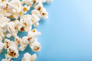 Parlak mavi bir arka plan üzerinde patlamış mısır. Film. Fast food. Mısır