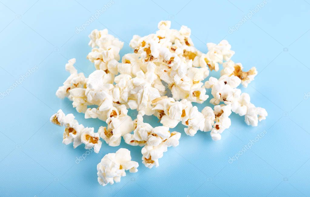 Popcorn on a bright blue background. Film. Fast food. Corn