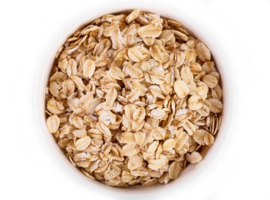 Beyaz arka planda yulaf ezmesi yığını. Beyaz arka planda izole edilmiş organik yulaf ezmesinden yapılmış yaratıcı bir düzen. Yiyecek konsepti.