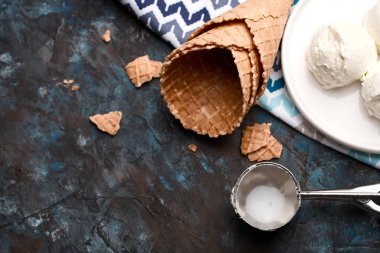 Dondurma topları, kaşık toz ve gözleme koniler koyu arka plan üzerinde. Reklam alanı. 