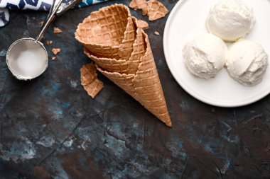 Dondurma topları, kaşık toz ve gözleme koniler koyu arka plan üzerinde. Reklam alanı. 