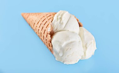 Mavi bir arka plan üzerinde bir gözleme külah dondurma topları. Vanilyalı dondurma waffle koni.