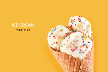 Dondurma topları renkli şeker sprinkles bir gözleme koni üzerinde sarı bir arka plan ile. Vanilyalı dondurma waffle koni.
