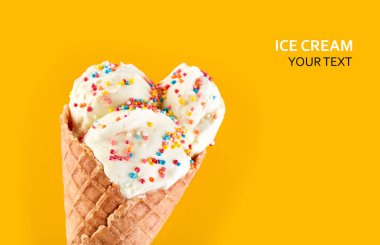 Dondurma topları renkli şeker sprinkles bir gözleme koni üzerinde sarı bir arka plan ile. Vanilyalı dondurma waffle koni.