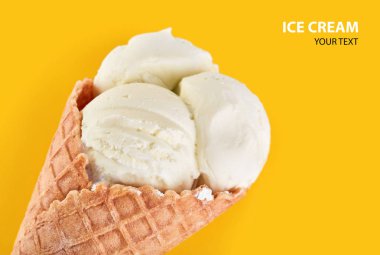 Dondurma topları renkli şeker sprinkles bir gözleme koni üzerinde sarı bir arka plan ile. Vanilyalı dondurma waffle koni.