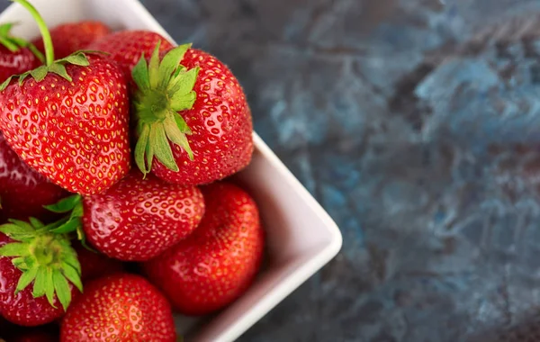 Fresh red strawberry on a dark abstract background. Summer berries. The concept of healthy eating.