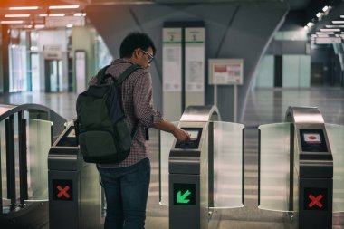 Akıllı kart kullanarak genç asian traveler kitle hızlı Transit (Mrt) tren Kuala Lumpur adlı kapıyı geçmek. Kuala Lumpur, Malezya demiryolu sisteminin büyük bileşeni oluşturan Mrt sistem.
