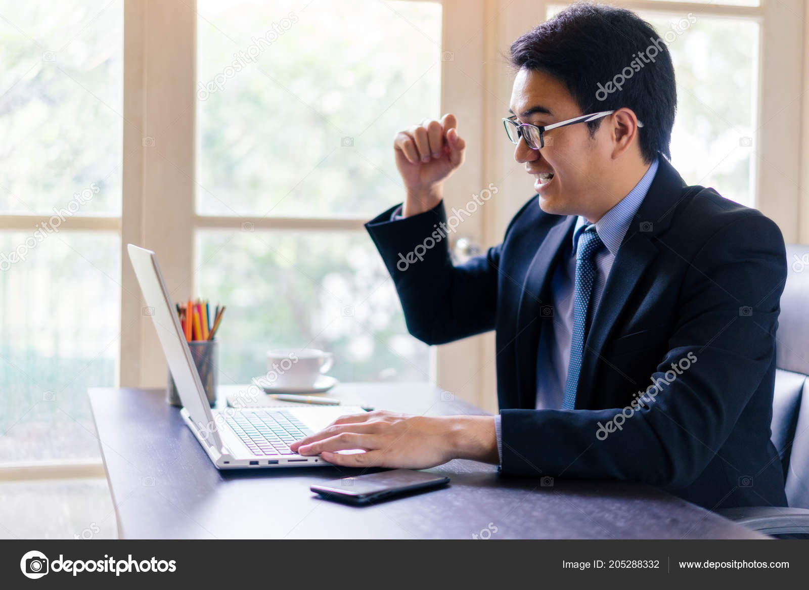 Young Happy Businessman Using His Laptop Glad While Raise Fist