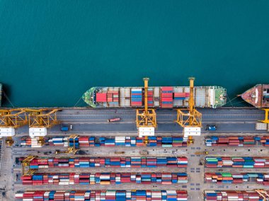 Top view of international port with Crane loading containers in import export business logistics.