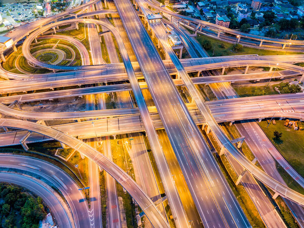 Top view of Highway road junctions at night. The Intersecting freeway road overpass the eastern outer ring road of Bangkok, Thailand.