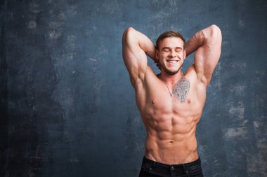 Stüdyoda seksi kaslı erkek modeli. Genç budybuilder uygun güçlü sportif adam kameraya poz. Çıplak gövdeli adam.