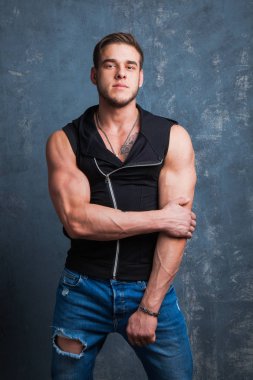 Stüdyoda seksi kaslı erkek modeli. Genç budybuilder uygun güçlü sportif adam kameraya poz. Spor moda konsepti